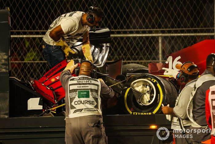 Un oficial de pista retira el alerón delantero del coche de Charles Leclerc, Ferrari SF21, del circuito