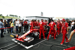 L'équipe Ferrari essaie de réparer la voiture de Kimi Räikkönen sur la grille, sous les yeux du journaliste Jonathan Noble