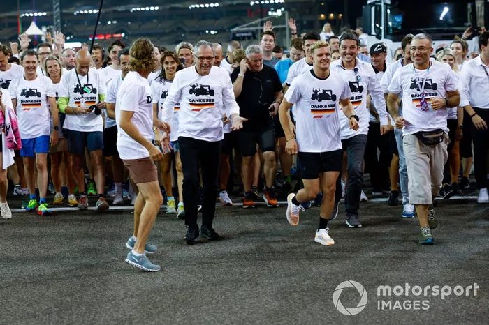 Sebastian Vettel, Aston Martin, es acompañado en una carrera alrededor del circuito por los miembros del equipo con la playera de Danke Seb como parte de su despedida en su último Gran Premio