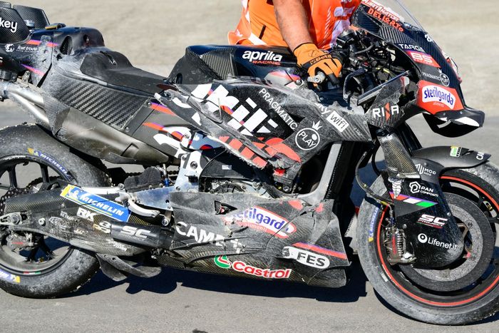   Разбитые фабричные гонки Aprilia выдвигаются обратно в загон.