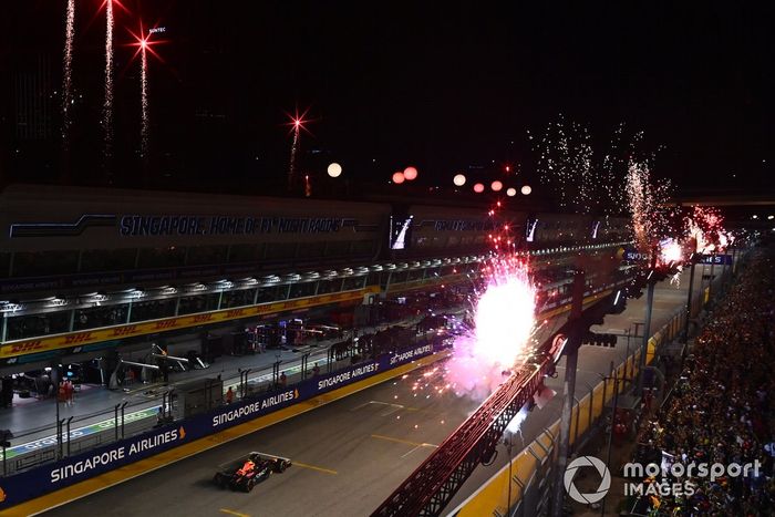 Los fuegos artificiales iluminan el cielo mientras Sergio Pérez, el RB18 de Red Bull Racing, en primera posición, consigue la victoria