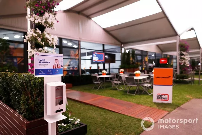 Dispensador de desinfectante de manos fuera del área de hospitalidad vacío de McLaren en el paddock