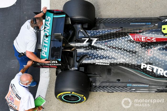 Los escrutadores mueven el coche del hombre de la pole Valtteri Bottas, Mercedes AMG F1, en el Parc Ferme