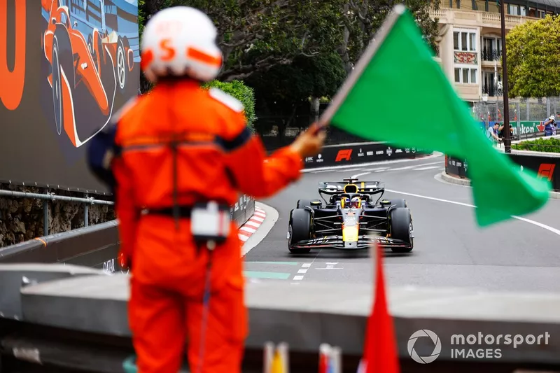 Un maréchal agite un drapeau vert alors que Max Verstappen, Red Bull Racing RB20, s'approche.