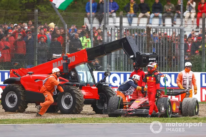 Los oficiales asisten a Carlos Sainz Jr., Ferrari F1-75, en la grava