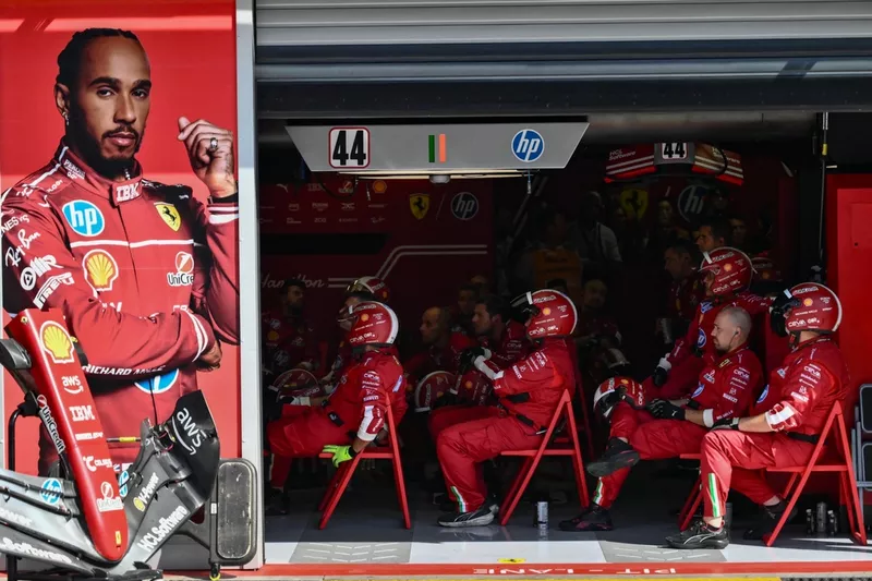 Les mécaniciens de l'équipe Ferrari suivent la course dans les stands lors du Grand Prix d'Italie de Formule 1 sur le circuit Autodromo Nazionale Monza, à Monza, dans le nord de l'Italie, le 7 septembre 2025. (Photo by Marco BERTORELLO / POOL / AFP) (Phot