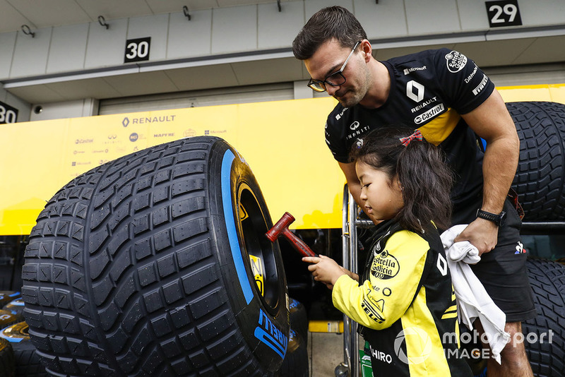 Young fans check out the Pirelli tyres of the Reanult team.