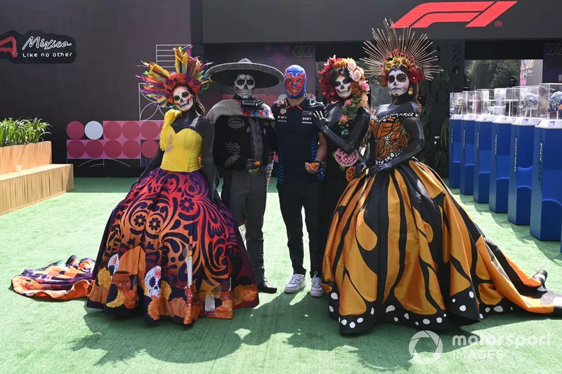 Sergio Perez, Red Bull Racing, poses with people wearing Calaveras make up as he arrives at the track 