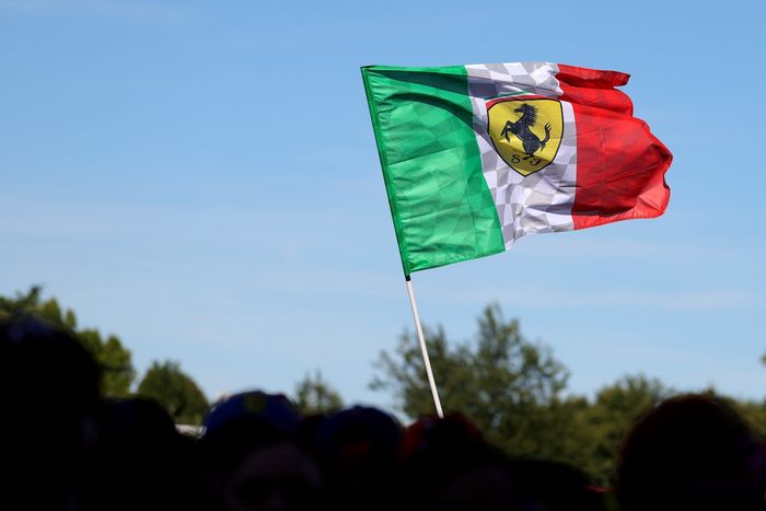 A Ferrari flag is raised by fans prior to final practice.