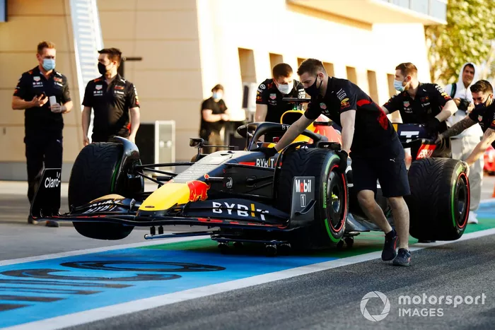 Los mecánicos empujan el coche de Max Verstappen, Red Bull Racing RB18, por el pitlane