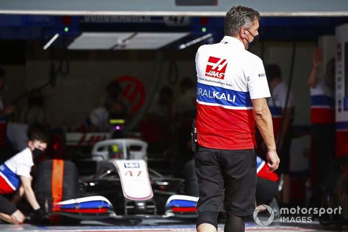 Un mecánico se pone en posición para dirigir a Mick Schumacher, Haas VF-21, fuera del garaje