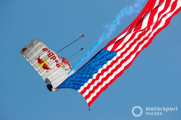 Un paracaidista llega con una bandera estadounidense