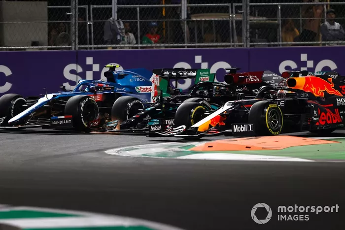 Max Verstappen, Red Bull Racing RB16B, Lewis Hamilton, Mercedes W12, y Esteban Ocon, Alpine A521, luchan por el liderato en el segundo reinicio