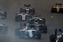 Valtteri Bottas, Williams FW38, Jenson Button, McLaren MP4-31 y Romain Grosjean, Haas VF-16, en la a
