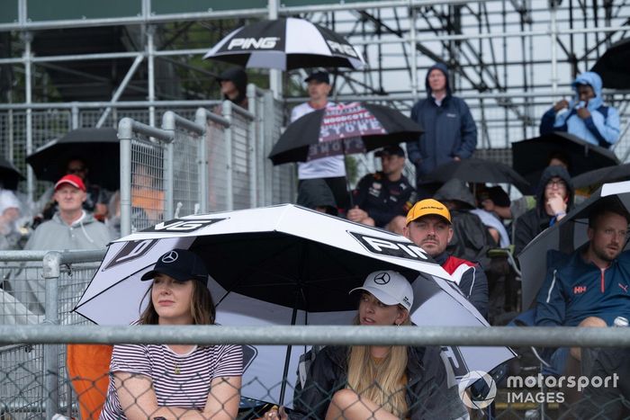 Aficionados bajo paraguas en una tribuna