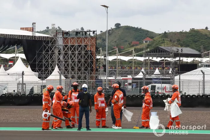 Comisarios limpiando después del fuego en la moto de Alex Rins