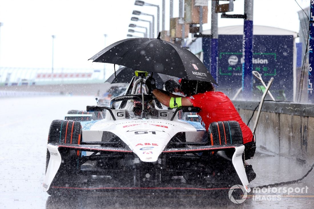 Nico Muller , Andretti Formula E es protegido de la lluvia por un miembro del equipo en el Pitlane