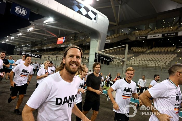 Sebastian Vettel, Aston Martin, es acompañado en una carrera alrededor del circuito por los miembros del equipo con la playera de Danke Seb como parte de su despedida en su último Gran Premio