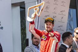 Sebastian Vettel, Ferrari celebrates on the podium with the trophy
