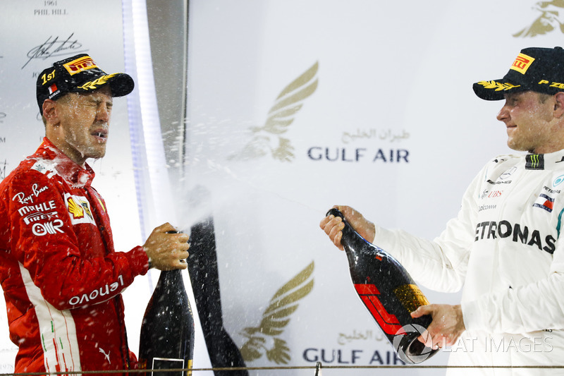 Sebastian Vettel, Ferrari, 1st position, and Valtteri Bottas, Mercedes AMG F1, 2nd position, spray W