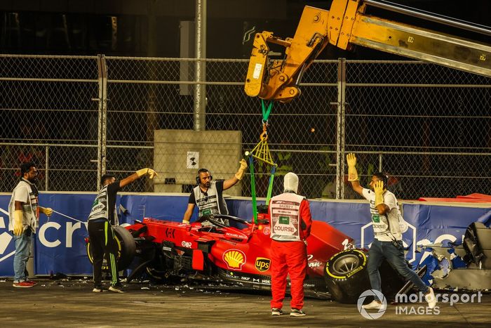 Los oficiales de pista retiran el coche de Charles Leclerc, Ferrari SF21, del circuito