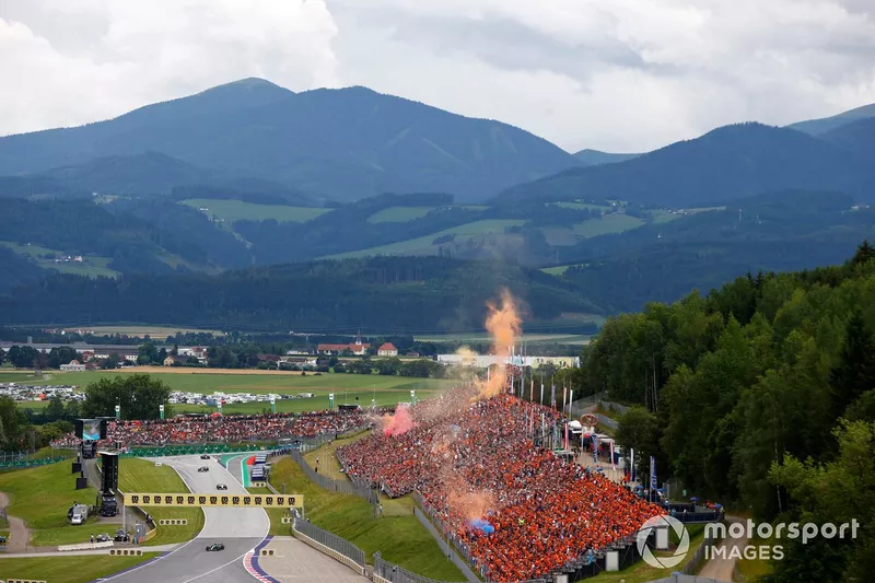 Fernando Alonso, Aston Martin AMR23, Nico Hulkenberg, Haas VF-23, nel giro di formazione, mentre dalla tribuna esce del fumo arancione.