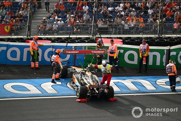Los comisarios se ocupan del coche dañado de Oscar Piastri, McLaren MCL60