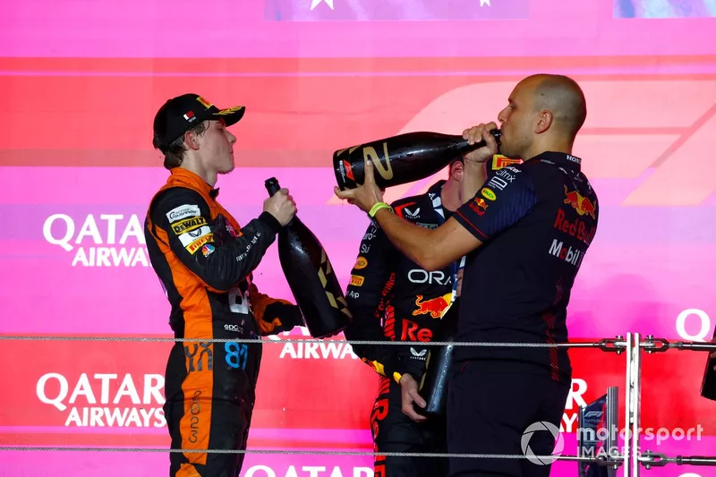 Oscar Piastri, McLaren, 2a posizione, Max Verstappen, Red Bull Racing, 1a posizione, Gianpiero Lambiase, ingegnere di gara, Red Bull Racing, prende un drink sul podio