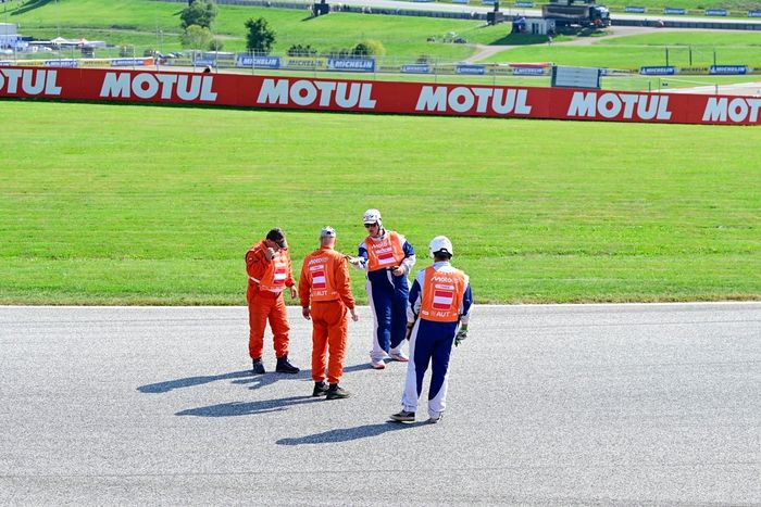 The marshals check the track after a red flag.