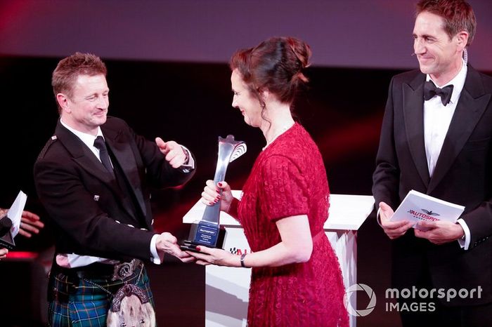 Allan McNish en el escenario para entregar el Premio Pionero y de Innovación a Catherine Bond Muir de la W Series
