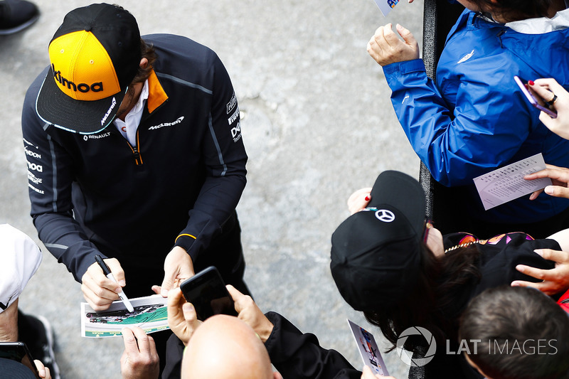 Fernando Alonso, McLaren, signs autographs for fans