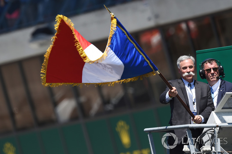 Chase Carey, FOM CEO waves the French flag to give the start of the race