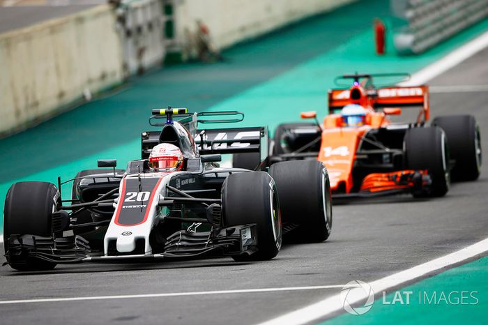 Kevin Magnussen, Haas F1 Team VF-17, Fernando Alonso, McLaren MCL32, en pit lane
