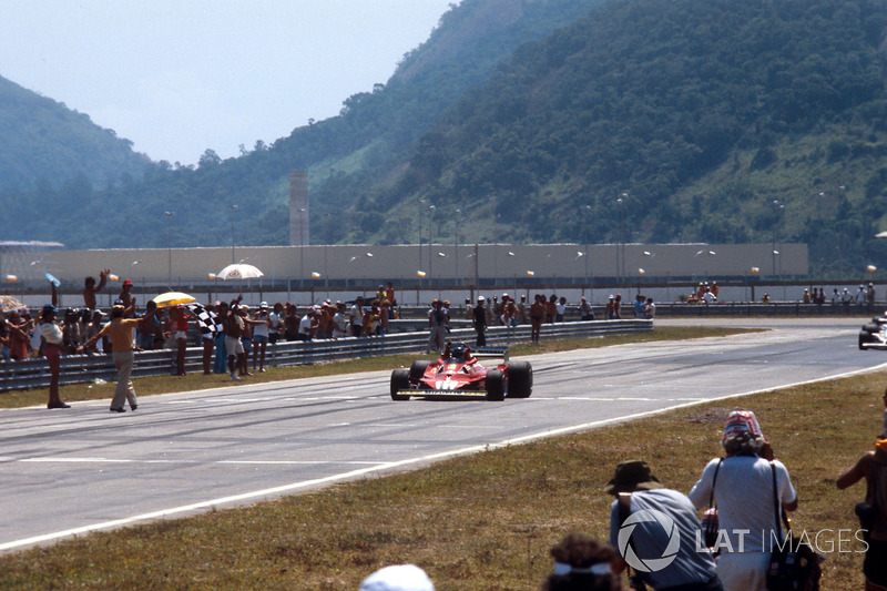 Carlos Reutemann, Ferrari 312T2, takes the chequered flag