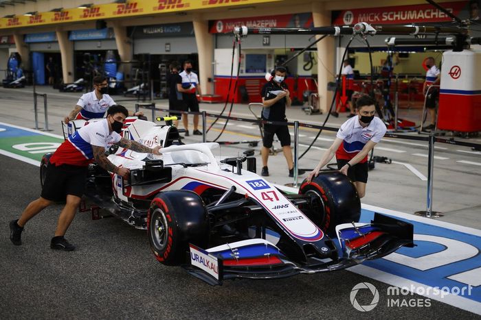 Los mecánicos empujan el VF-21 de Mick Schumacher Haas en el pit lane