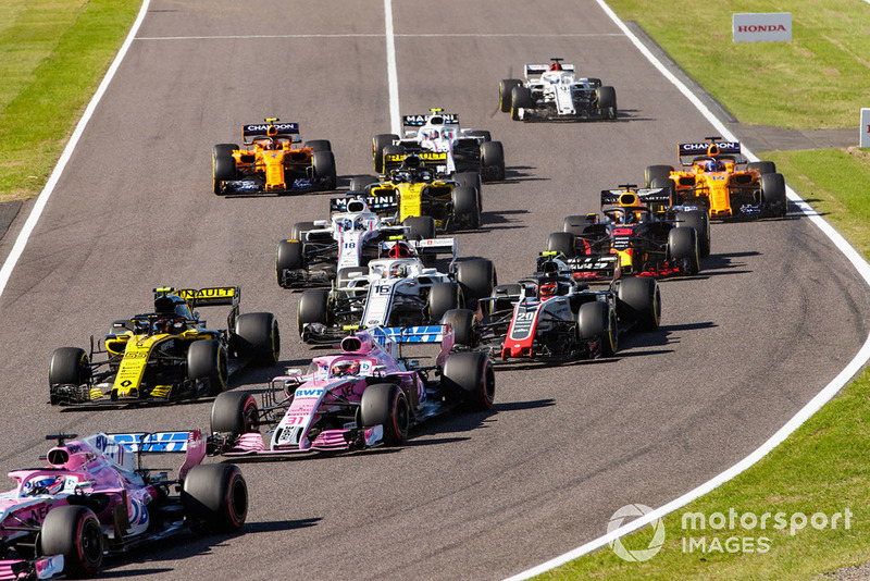 Sergio Perez, Racing Point Force India VJM11, leads Esteban Ocon, Racing Point Force India VJM11, Carlos Sainz Jr., Renault Sport F1 Team R.S. 18, Kevin Magnussen, Haas F1 Team VF-18, Charles Leclerc, Sauber C37, and the remainder of the field at the start