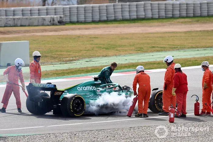 Oficiales de pista asisten a Sebastian Vettel, Aston Martin AMR22, después de que un fallo técnico produzca humo