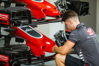 A Haas F1 Team mechanic at work on VF-18 nose and front wing assemblies
