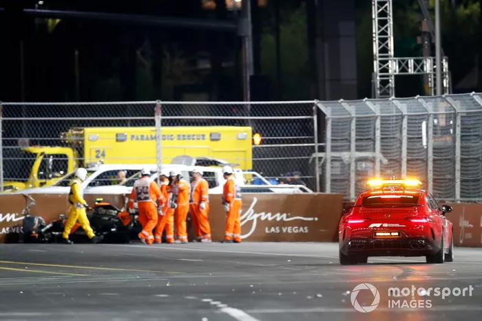 Los comisarios y el coche médico junto al coche accidentado de Lando Norris, McLaren MCL60