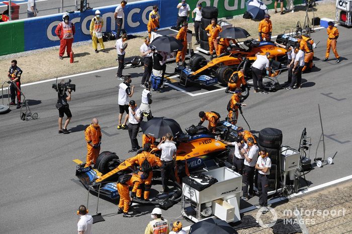 Los mecánicos preparan los coches de Carlos Sainz Jr., McLaren MCL35, Lando Norris, McLaren MCL35, en la parrilla