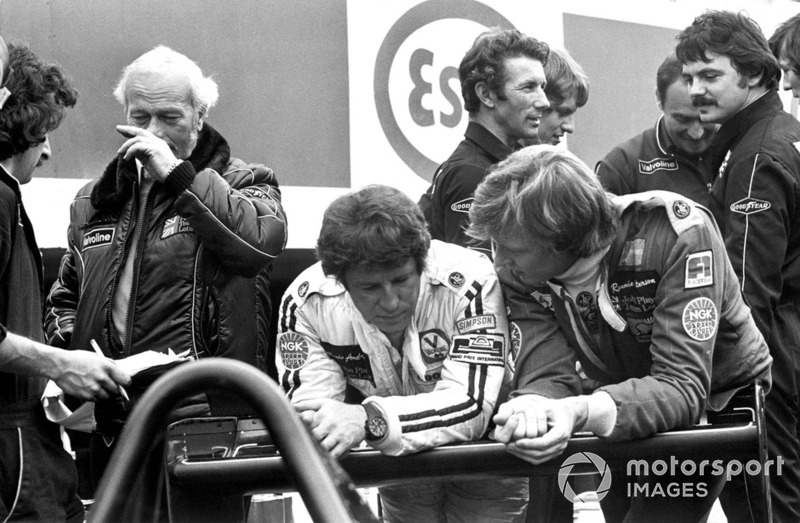 Mario Andretti y Ronnie Peterson hablan en el pit lane con el jefe del equipo Colin Chapman, Lotus
