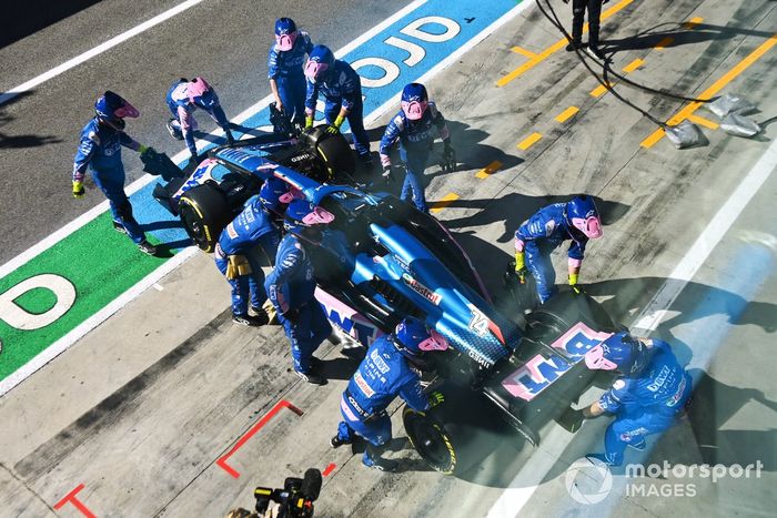 Los mecánicos de Alpine empujan el coche retirado de Fernando Alonso, el Alpine A522, hacia el garaje