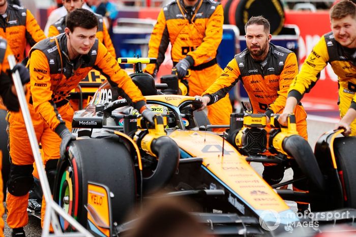 Los mecánicos llevan a Lando Norris, McLaren MCL60, a la parrilla de salida