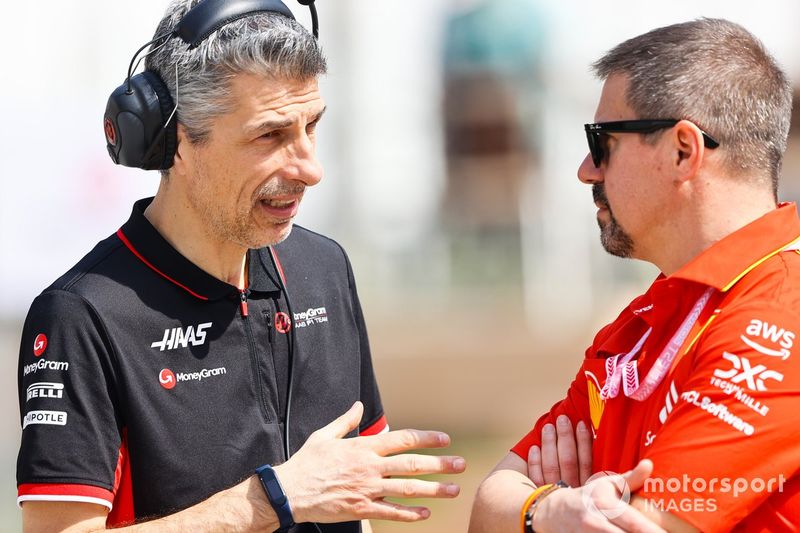 Un ingeniero del equipo Haas F1 habla con un miembro de la Scuderia Ferrari.