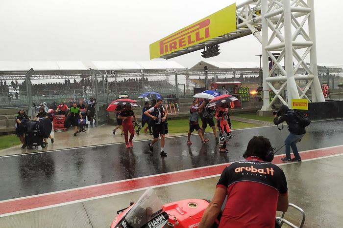 Los pilotos y equipos corren bajo la lluvia de vuelva a boxes