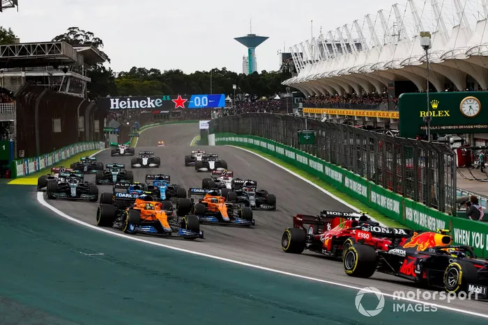 Sergio Pérez, Red Bull Racing RB16B, Charles Leclerc, Ferrari SF21, Pierre Gasly, AlphaTauri AT02, Lando Norris, McLaren MCL35M, Daniel Ricciardo, McLaren MCL35M, y el resto del grupo en la primera vuelta