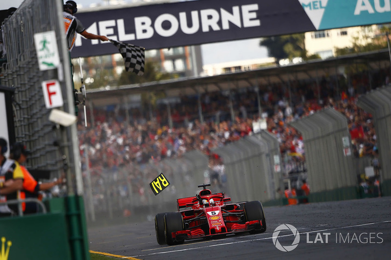 Sebastian Vettel, Ferrari SF71H, passe sous le drapeau à damier alors qu'une partie du panneau Ferrari s'est cassée