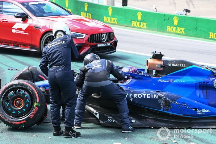 Delegados médicos de la FIA asisten a Alex Albon, Williams FW45, tras un choque en la salida con Kevin Magnussen, Haas VF-23