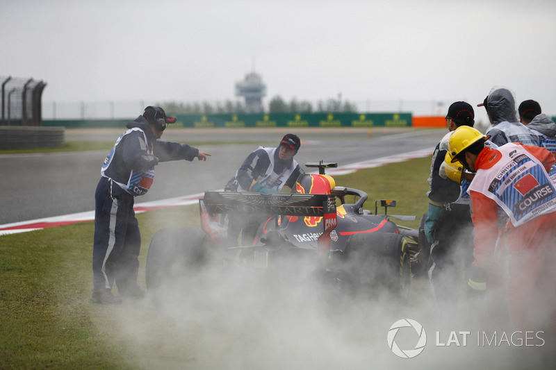 Marshals use fire extinguishers on the Daniel Ricciardo Red Bull Racing RB14 Tag Heuer