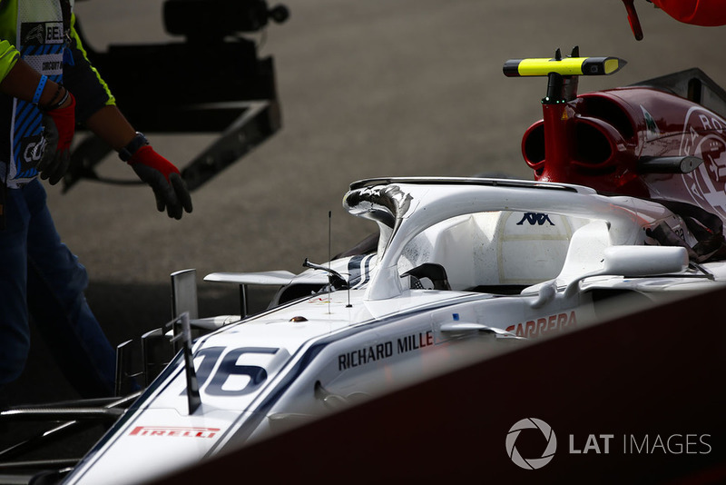 Marshals remove the damaged car of Charles Leclerc, Sauber C37, after a crash on the opening lap